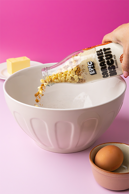 Caramel Biscuit Blondie Mix being poured in mixing bowl